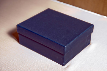 Gift box on the table . The blue box is on the white table .