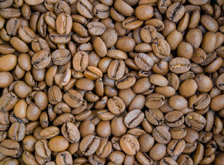Roasted brown coffee beans close up background