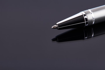 Luxury silver colored ball pen isolated on dark background. copy space. Signature, agreement, businessman concept.