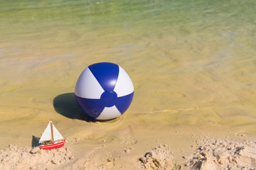 Toy boat and Inflatble beach ball floating on water