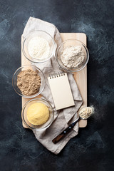 Baking background with ingredients for gluten-free baking,vegetable corn,sesame,oat,coconut flour and space for your recipe on kraft paper.Alternative to wheat flour for keto paleo diet concept