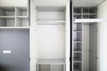 Close-up of empty closet space in room. Many shelves and expanse. Cupboard or wardrobe for people clothes. New purchased property. Moving day and renovation concept