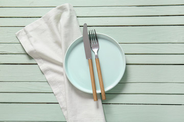 Clean plate and cutlery on wooden background