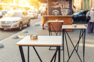European city street urban bistro cafe epmty tables without people during quarantine. Snack bar with food to go evening sunset or morning sunrise light. Citiscape scene on summer day. Travel concept