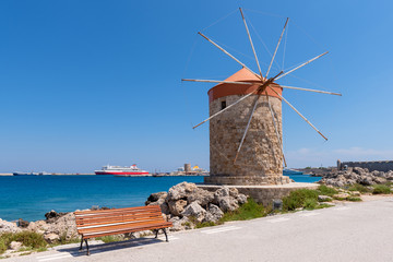 Fototapeta na wymiar Historic windmill overlooking Mandraki port. Rhodes island, Greece