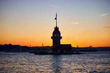Fiery sunset over Bosphorus with famous Maiden's Tower (Kiz Kulesi in Turkish) also known as Leander's tower, symbol of Istanbul, Turkey