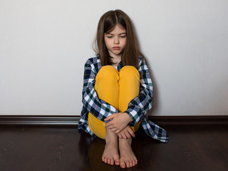 sad teenage girl sitting on the floor. Child protest, the problem of the relationship between adolescents and parents, adolescent psychology, concept