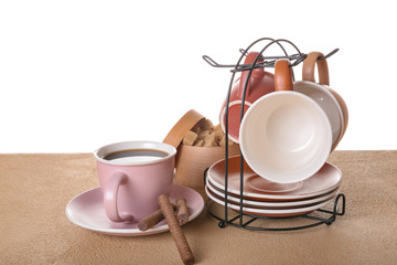 Holder with cups and saucers on table against white background