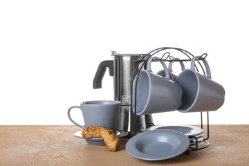 Holder with cups and saucers on table against white background