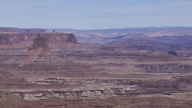 A long-lens timelapse looking across at a distant mesa in Canyonlands National Park, as seen from Dead Horse Point State Park on a cloudy winter afternoon.