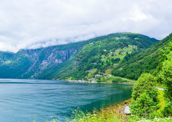 Fototapeta premium Landscape of the serpentine Eagles Road, rising along the slope of the mountain above the Geirangerfjord near the village of Geiranger.
