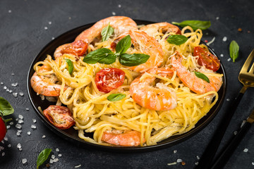 Pasta seafood with shrimp on black table.