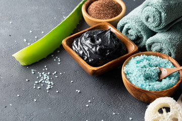 The concept of the bathroom or spa. Natural cosmetics for the body and face. Sea salt, dead sea mud, scrub of coffee on a dark table. Copy space.