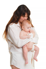 young brunette mom with long hair and a white shirt holds a newborn son. A 4 month old baby in her arms. Isolate