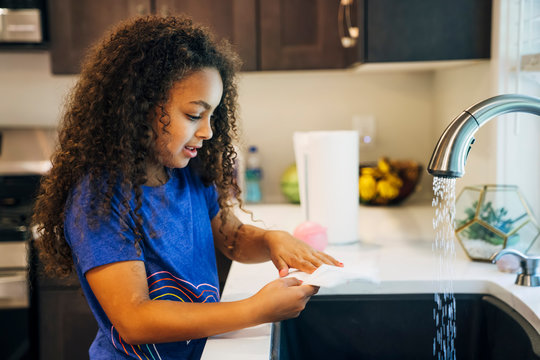 Girl washing at kitchen sink
