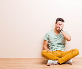 young arabian man laughing and slapping forehead like saying d‚Äôoh! I forgot or that was a...