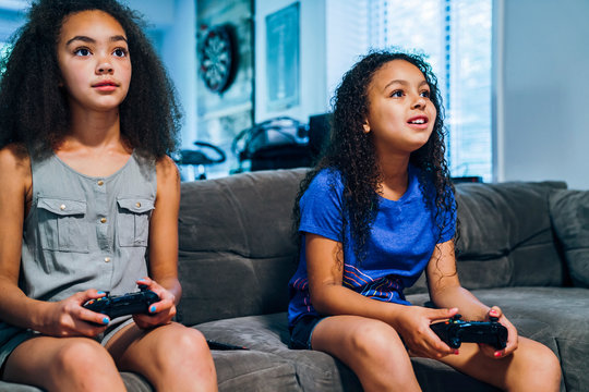 Girls playing video games together on couch