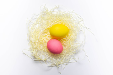 Two Easter eggs in nest isolated on white background. Happy holiday card, close-up, copy space