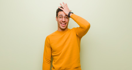 young arabian man raising palm to forehead thinking oops, after making a stupid mistake or...