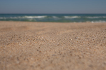 Fototapeta na wymiar Sand on the beach close-up and sea on the background. Selective focus.