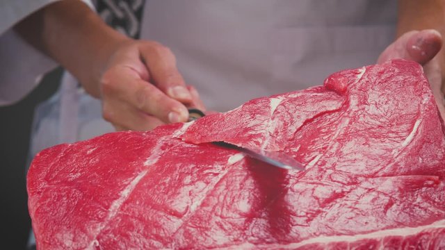 Unrecognizable cook cutting raw tuna