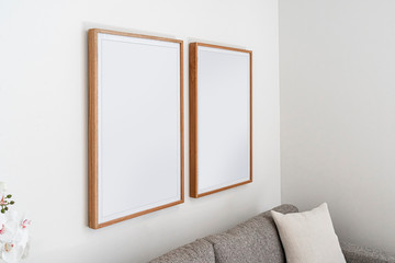 Interior decoration, empty wooden vertical frames, poster white canvas mock up on a white wall,...