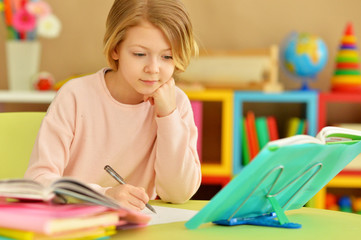 Cute teen girl doing homework in her room
