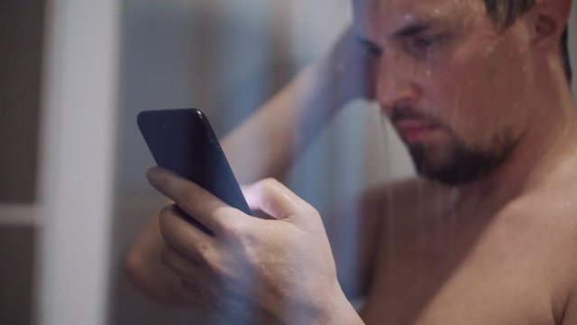 man with nomophobia is using smartphone in shower
