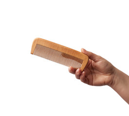 female hand holds wooden hairbrush isolated on a white background