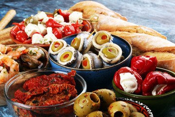Antipasti Appetizer sweet cherry peppers stuffed with soft cheese feta, olives with oil. Seafood and anchovies with olives and dried tomatoes in oil