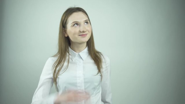 fashionable girl in white blouse fixes flowing hair by wall