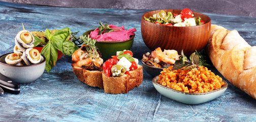 Antipasti Appetizer sweet cherry peppers stuffed with soft cheese feta, olives with oil. Seafood and anchovies with olives and dried tomatoes in oil