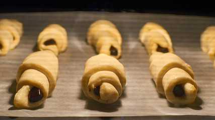Baking croissants with chocolate in the oven - close-up of the growth of pastry