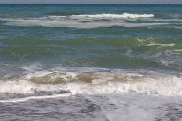 Sea, sea waves and shoreline on a sunny windy day.