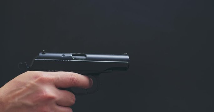 man shutter cocking and shoots with air pistol on black background the gun ran out of ammunition