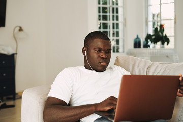 men of african appearance at home in front of a laptop