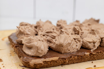 Chocolate cream on the cake. Preparing chocolate cake