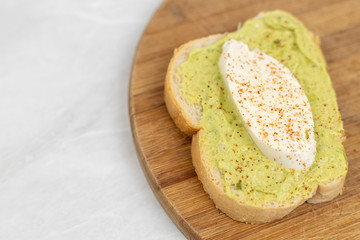 Sliced mozarella on the avocado spread toast