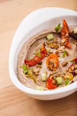 Organic plant based hummus with granola dried tomatoes toppings. Perfect for vegan gluten free. Freshly homemade for takeaway and delivery. Healthy food photography.