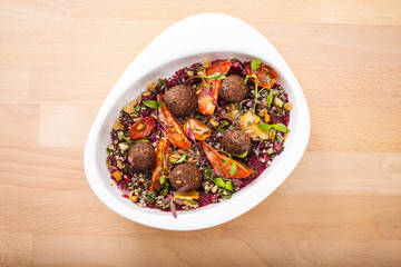 Delicious healthy salad with falafel and dried tomatoes. For healthy living. Perfect for takeaway and delivery. Vegan food photography.