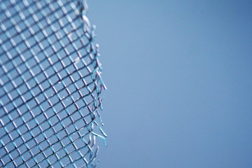 Abstract metal mesh fence closeup blue monochrome for banner with empty space for text