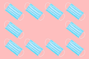 many blue medical face masks isolated on a pink background. copy space. flat lay. concept of protection against viruses, bacteria. background for medical subjects
