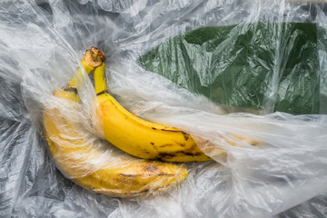 yellow ripe bananas with a plastic film polyethylene abstraction