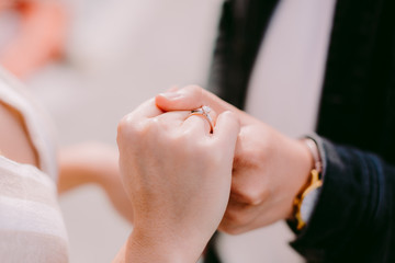 engaged couple holding hands with engagement ring