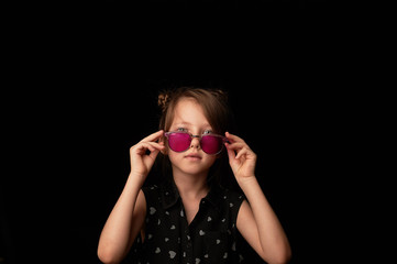 Obraz premium A girl of 6 years in pink glasses. Childhood, naive view of the world.