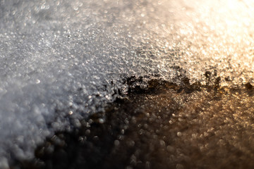 melting snow on the ground illuminated by sunbeams, spring