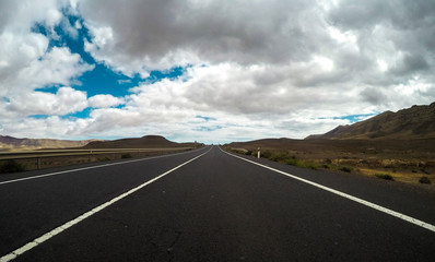 Ground beautiful view of long way straight asphalt road and blue clouds sky in background - concept of drive and travel with vehicle - beauty nature park outdoor place and way