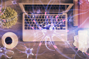 Neuron hologram drawings over computer on the desktop background. Top view. Multi exposure. Concept...