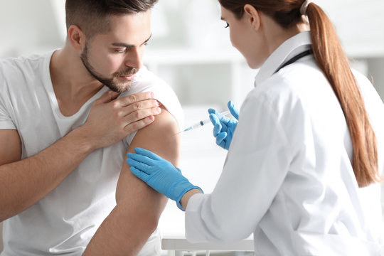 Doctor giving injection to patient in hospital. Vaccination concept