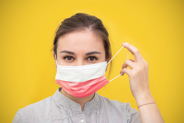 Young beautiful woman takes off protective sterile medical mask in the national flag of Poland. Happy end. Victory over coronavirus. Pandemic Covid-19.
